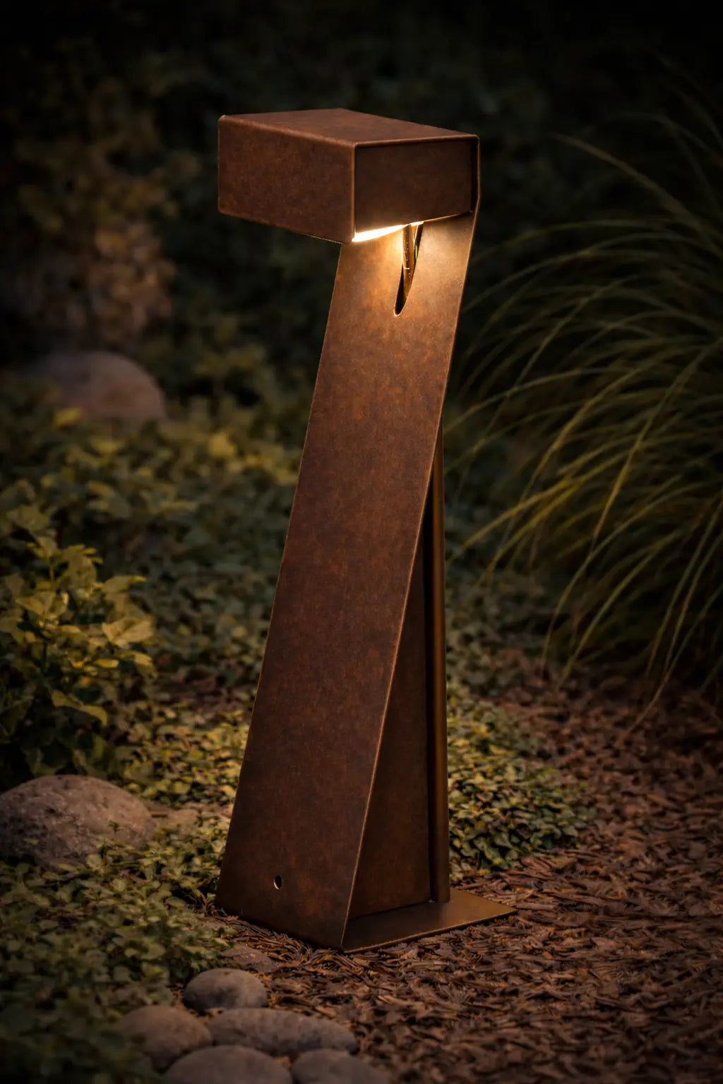 lampione faretto LED da giardino in acciaio corten acceso con luce calda per illuminazione esterna